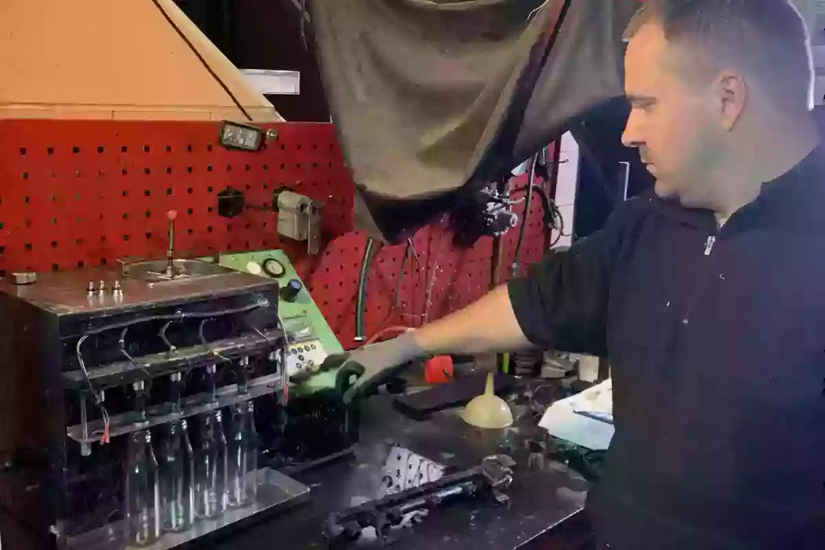 Мастер чистит форсунки